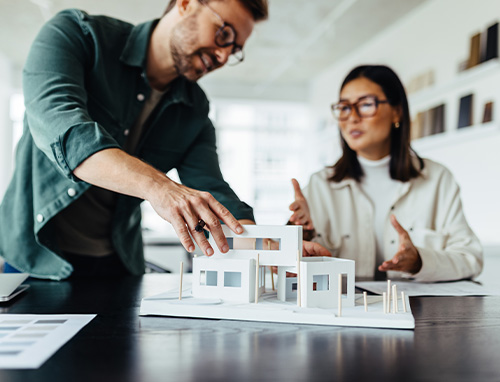 zwei Architekten unterhalten sich über ein Gebäudemodell